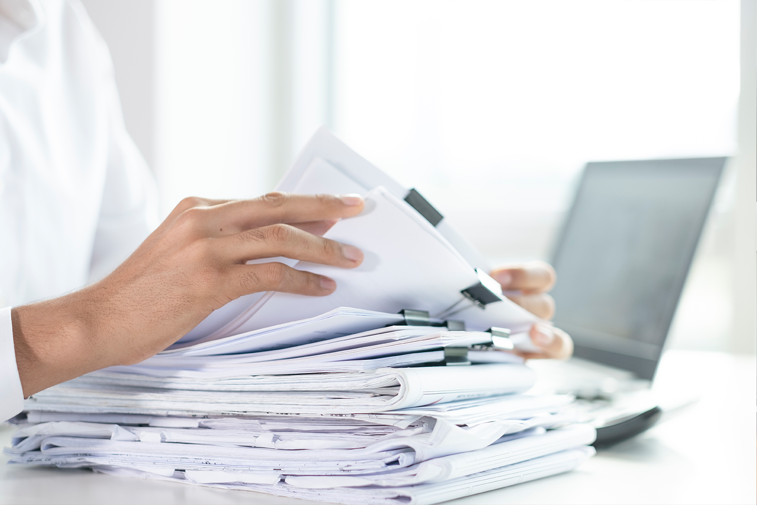 stack of papers with someone working on them